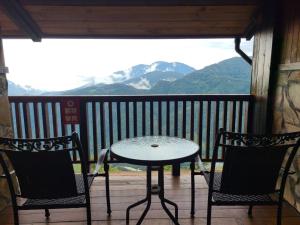 a table and two chairs on a balcony with mountains at Top Cloud Villa in Renai