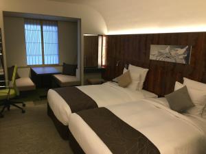 a hotel room with two beds and a desk at ANA Crowne Plaza Hotel Kyoto by IHG in Kyoto