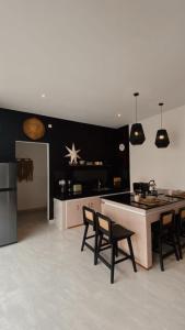a kitchen with chairs and a table and a counter at Villa Hope Bali in Kerobokan