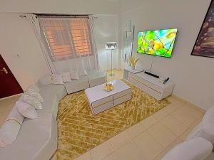 a living room with a couch and a flat screen tv at Lavish Homely Apt 5 in Kisumu