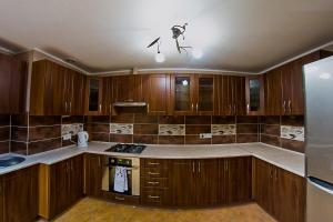 a kitchen with wooden cabinets and a stove top oven at Apartment Sweet Home Sanok in Sanok