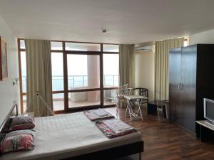 a bedroom with a large bed and a large window at Sozopol Sunrise in Sozopol