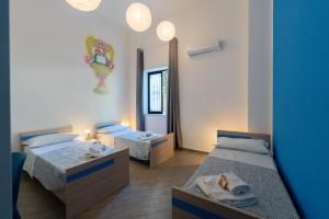 巴勒莫Cortile dei Giusti - Combo Guesthouse的有两张床和一面镜子的房间