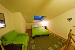 サノクにあるApartment Sweet Home Sanokの小さなベッドルーム(緑のベッド1台、椅子付)