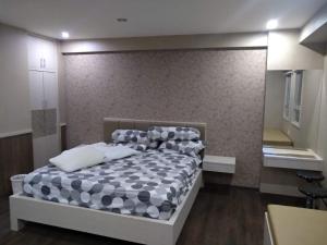 a bedroom with a bed with a black and white comforter at For rent or sale Puncak Kertajaya apartment in Surabaya