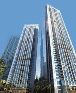 two tall buildings in a city with the burj at Downtown views prime location Dubai mall in Dubai