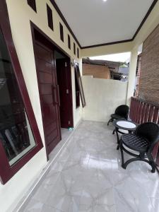 a balcony with chairs and a table and a door at Parkside nest-studio 3 in Kuta Lombok