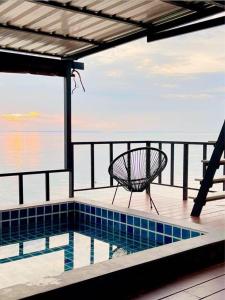 a bench sitting on a deck next to a swimming pool at อาวารินวิลล่า Awarin villa in Ban Tanjong In +16 photos