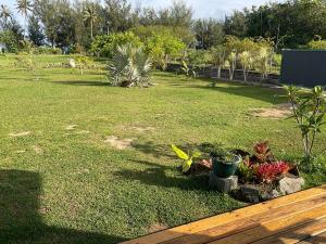 a yard with a wooden bench and some plants at Tubuai Fun Lodge in Tubuai