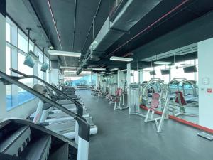 a gym with rows of treadmills and chairs at Peaceful and Airy 1-bedroom Apartment with the Palm beach view in Dubai