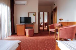 a hotel room with a television and a living room at Hotel Hermes in Alba Iulia