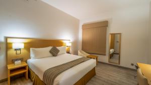 a hotel room with a bed and a mirror at Aram Hotel - AlMeshael Exit 18 in Riyadh