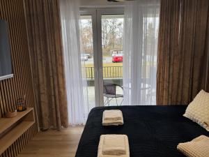 a bedroom with a bed with two towels on it at Apartament Zamojskie Echo in Zamość
