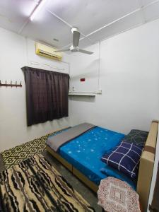 a bedroom with a bed and a ceiling fan at Orchid Homestay Pasir Gudang in Pasir Gudang