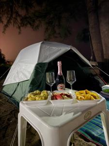 Ban Mai SalaeTENT Maikhao的桌子上有两个酒杯和一瓶酒