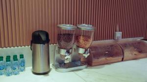 a couple of coffee grinders sitting on top of a counter at Aram Hotel - AlMeshael Exit 18 in Riyadh
