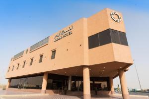 a building with a clock on the side of it at Aram Hotel - AlMeshael Exit 18 in Riyadh