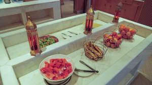 a counter with two bowls of fruit and a bowl of food at Aram Hotel - AlMeshael Exit 18 in Riyadh
