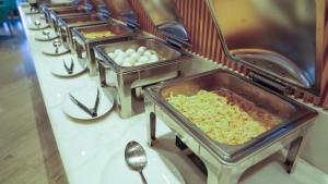 a row of trays of food on a table at Aram Hotel - AlMeshael Exit 18 in Riyadh