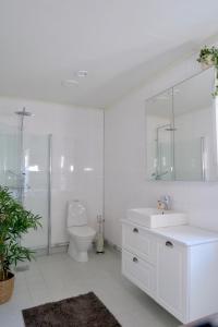 a white bathroom with a sink and a toilet at House near Umeå for rent in Umeå