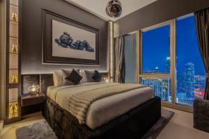 una camera da letto con un letto grande con una grande finestra di Brand New LUXE Downtown Dubai 46th Floor a Dubai