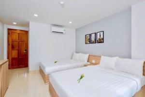 A bed or beds in a room at Luna House Hotel