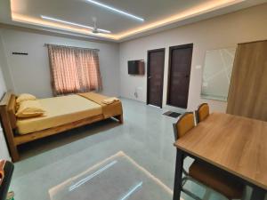 a room with a bed and a table in it at Sri Abirami Mahal in Tiruvannāmalai