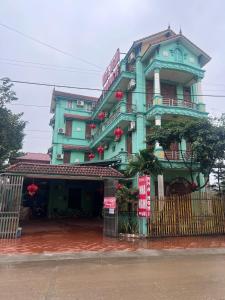 a green building with a fence in front of it at Nhà nghỉ Phương Lệ in Tiên Tân