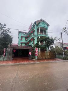a green building on the corner of a street at Nhà nghỉ Phương Lệ in Tiên Tân