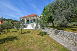 a house with a stone wall and trees at Apartment House Zdrelac - Meri in Ždrelac