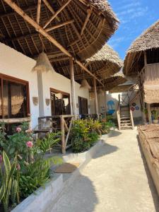 a building with a straw umbrella and some plants at BOUGAIN VILLA -nice for couple in Nungwi