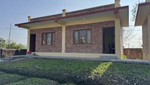 a small brick house with a front door at ROKPA Village Home Stay in Sundarijal