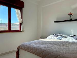 a white bedroom with a bed and a window at Apartment - Solarium in San Nicola Arcella +33 photos