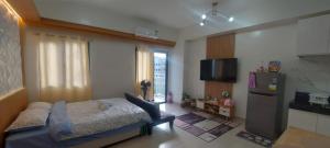 a bedroom with a bed and a refrigerator in a room at SMDC Hill Residences, Unit 601 in Manila