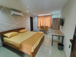 a bedroom with a bed and a table and a window at Sri Abirami Mahal in Tiruvannāmalai