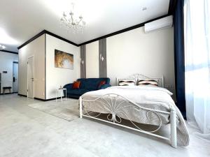 a bedroom with a bed and a blue couch at Apart Complex Meridian из 10 отдельных апартаментов рядом с Арбатом in Almaty