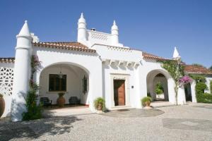 a white house with white columns and ivy at Monte dos Pensamentos - Turismo Rural in Estremoz