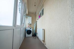 a hallway with a washing machine in a room at ByaResidence in Valea Lupului