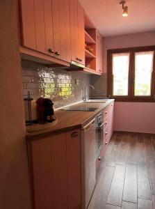 a kitchen with pink cabinets and a sink at Luxury suites in Villa Anasia, Olympia in Skotina