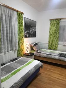 a bedroom with two beds and a window with curtains at Monteurzimmer Ostalb in Lauchheim