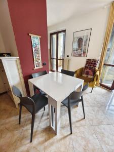 a dining room with a white table and chairs at Rogoredo - 10 min-Linate airport 100 m from the metro in Milan +12 photos