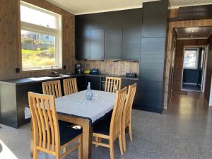 a kitchen with a table and chairs in a kitchen at Hytte med sjøutsikt in Bamble +22 photos