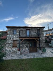 a stone house with a balcony on top of it at Luxury suites in Villa Anasia, Olympia in Skotina