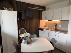 a kitchen with a table with chairs and a sink at Küstenliebe Graal-Müritz in Gelbensande