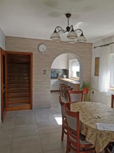 a kitchen and dining room with a table and chairs at Platán Ház Révfülöp in Révfülöp +3 photos
