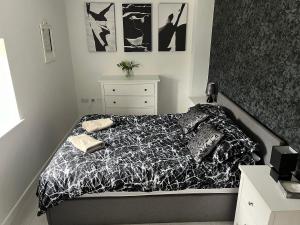 a bedroom with a bed with a black and white comforter at Plough Cottage in Bradfield