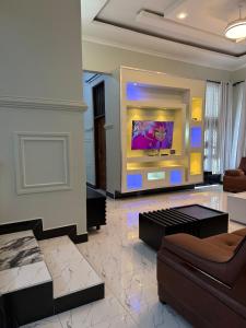 a living room with a couch and a flat screen tv at MASAI Apartment Goba in Dar es Salaam