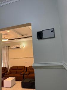 a living room with a couch and a tv on a wall at MASAI Apartment Goba in Dar es Salaam +28 photos