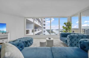 ein Wohnzimmer mit blauen Möbeln und großen Fenstern in der Unterkunft The Grand Wonder Biscayne in Miami