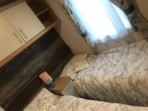 モーペスにあるLuxury Caravan Cresswellの小さなベッドルーム(ベッド2台、窓付)